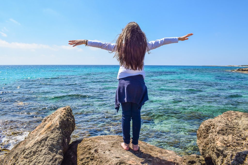girl standing at water (source Pixabay)